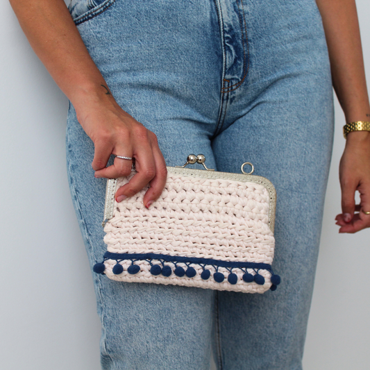 Hand clutch with pompom decoration